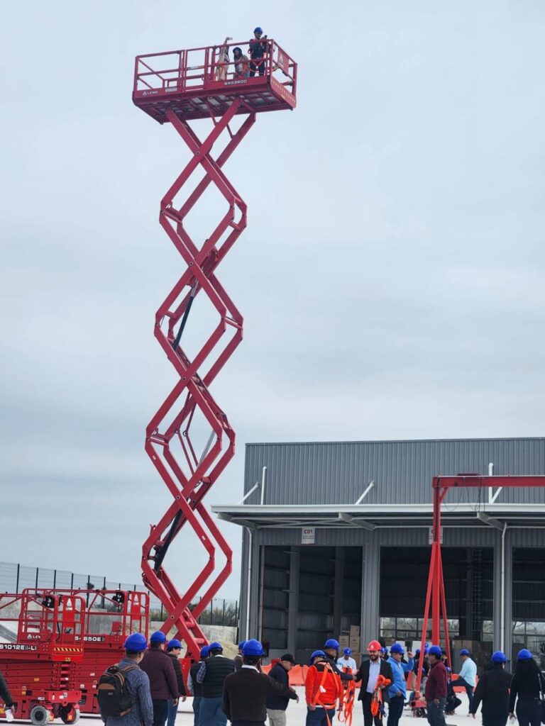 Plataforma de elevación roja de tijera abierta en un almacén