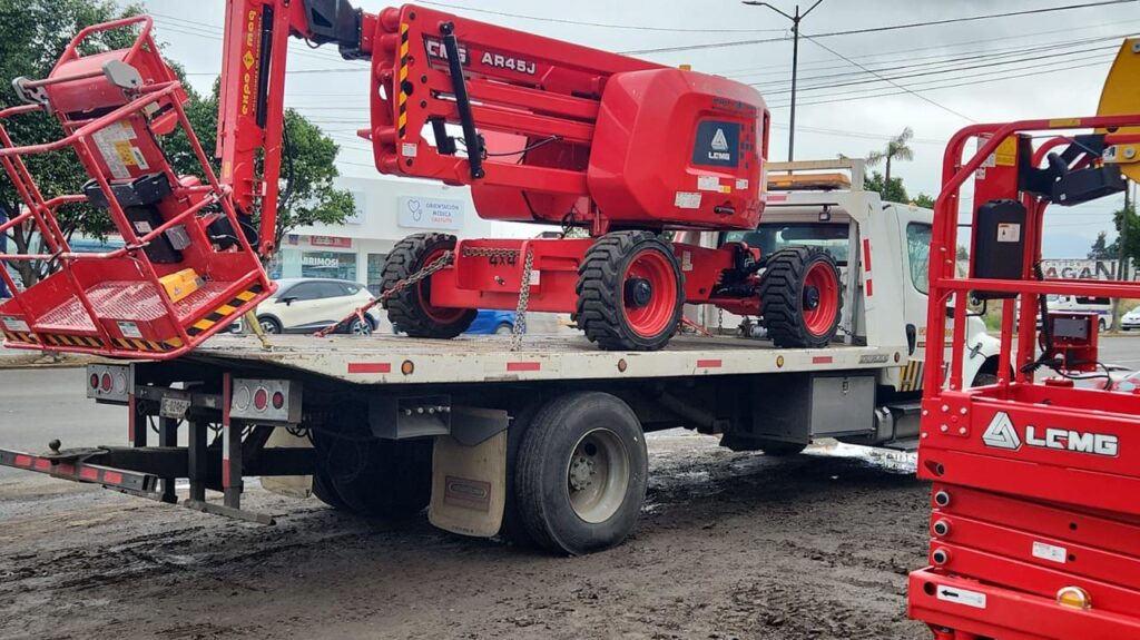 Plataforma de elevación roja de brazo sobre un camión de transporte